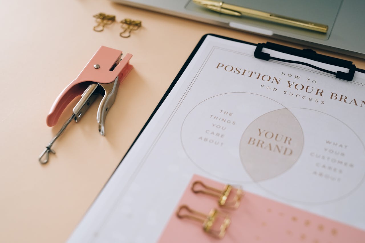 services-04 Pink stapler and branding document on a desk showcasing stylish office setup.